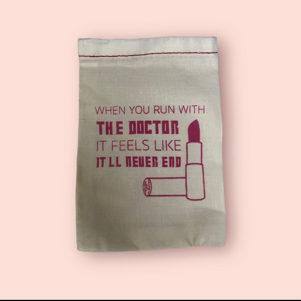 Dr. Who small white drawstring  cosmetic bag with pink writing.
